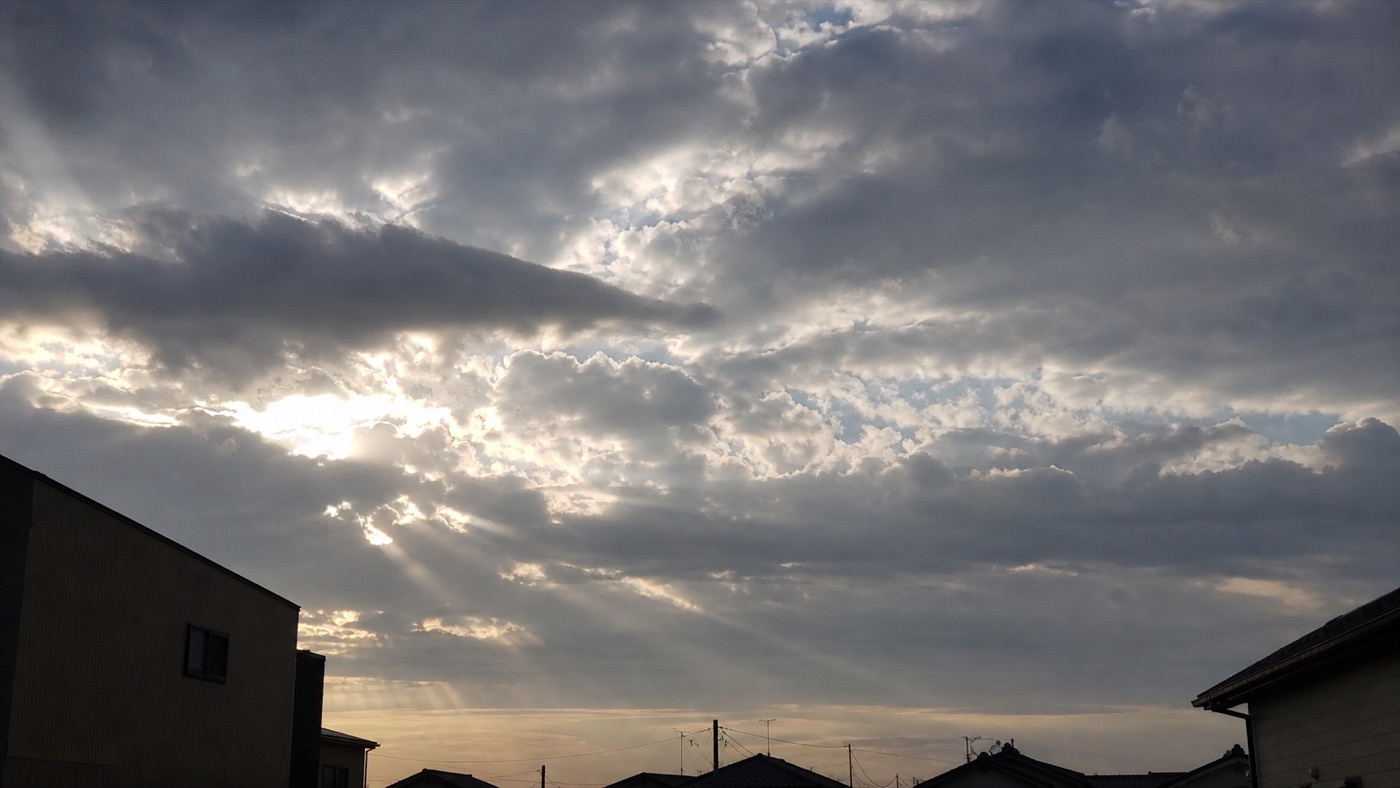 朝、雲の切れ間から太陽の光が差し込んでいる空