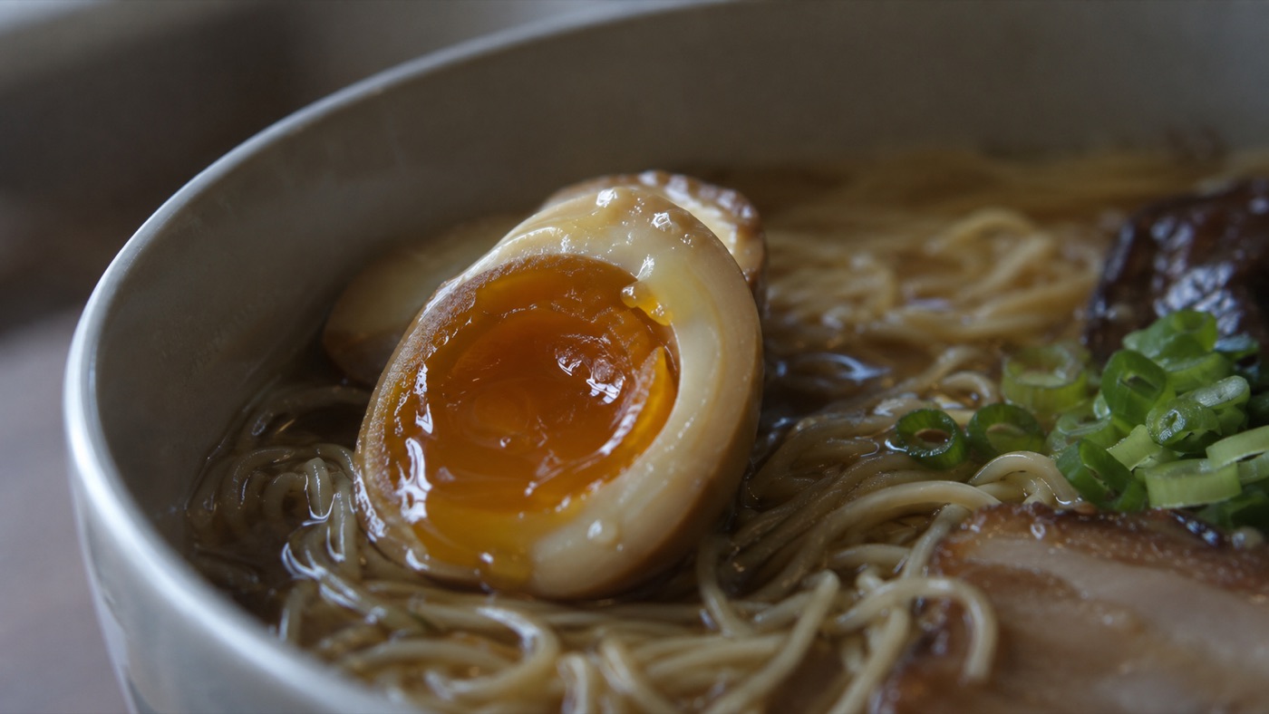 ラーメンの上の、つやのある味玉のクローズアップ